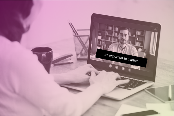 Someone at a laptop with a video showing captions on the screen