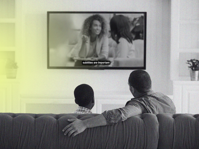 father and son watching TV with subtitles
